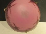 a pink glass ball sitting on top of a white table