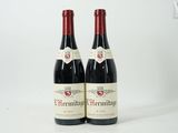 deux bouteilles de vin rouge posées l'une à côté de l'autre sur une surface blanche