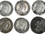 un ensemble de six pièces d'argent représentant des visages d'hommes et de femmes