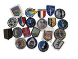 several different military badges are arranged in a circle on a white surface