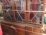 a wooden china cabinet with glass doors in a room