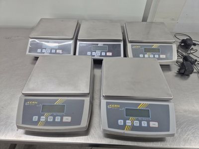 quatre balances électroniques posées sur une table dans une pièce