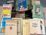 beaucoup de livres posés sur une table, avec un stylo