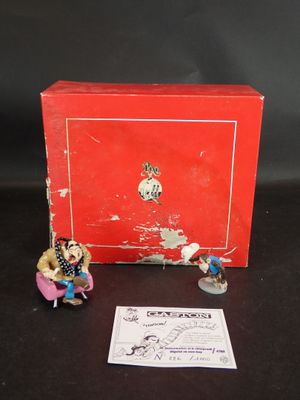 une boîte rouge sur laquelle sont posées deux figurines représentant des personnes assises