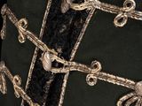 a close up of a black and gold jacket with buttons on it