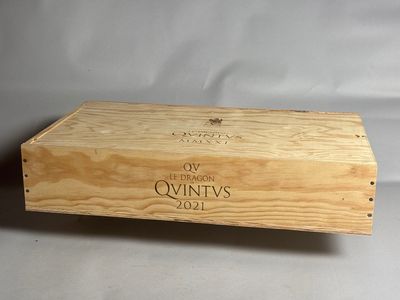 une vieille boîte en bois sur laquelle est collée une étiquette de vin, posée sur une table