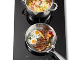 deux casseroles sur la cuisinière dans lesquelles cuit de la nourriture