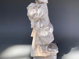 a white statue of a child with a hat on