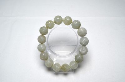 un bracelet composé de perles de jade vert montées sur un support transparent