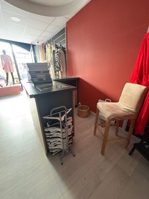 une robe rouge accrochée au mur à côté d'une chaise