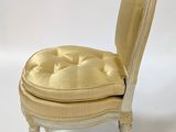 beige upholstered chair against a white backdrop with a white background
