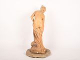 statue of a woman standing on a rock on a white background