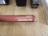 a tube of liquid sitting on a table next to a box of lipstick