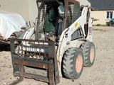 a picture of a skid steer loader parked in front of a building