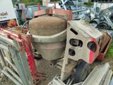 a cement mixer sitting in the middle of a pile of junk