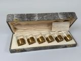 une photo d'un lot de six ronds de serviette en laiton présentés dans un coffret