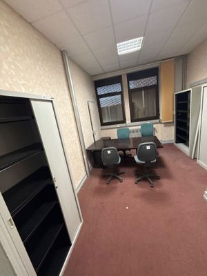 une pièce avec un bureau, des chaises et une bibliothèque