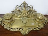 a gold tray with a pen and inkwell on top of it