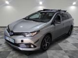 La Toyota Corollant est garée dans une grande pièce au sol carrelé en damier.