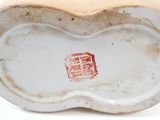a white vase with a red and yellow design on it