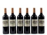 four bottles of wine are lined up on a white surface
