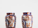 two vases sitting side by side on a white surface