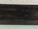 an old black suitcase sitting on a white surface
