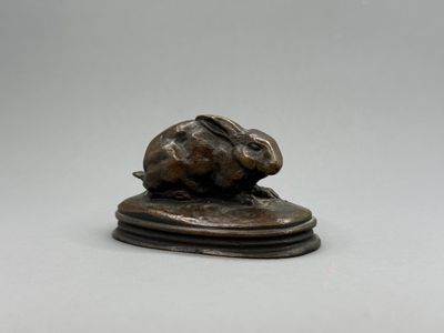 une figurine antique en bronze représentant un lapin sur un socle