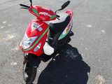 a red scooter parked on the side of the road