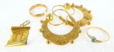 many gold rings and other gold jewelry on a white surface