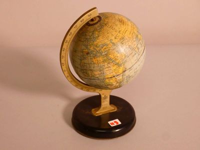 un petit globe terrestre posé sur un socle, sur une table