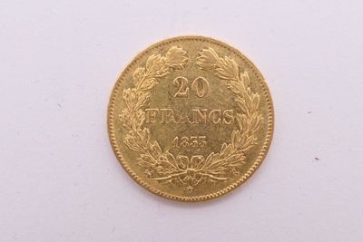gros plan d'une pièce d'or sur une surface blanche
