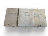 trois livres sont empilés sur une surface blanche