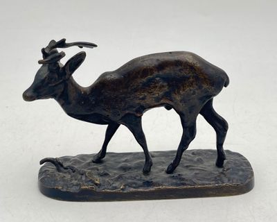 bronze statue of a goat on a rock with a white background