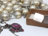 a necklace and a box of pearls on a table