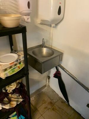 une photo d'une salle de bains avec un lavabo et une poubelle