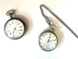 deux montres de poche posées l'une à côté de l'autre sur une table