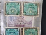 five different bank notes in a clear plastic case
