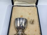 a small silver cup in a box on a table