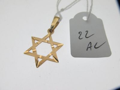 un pendentif en forme d'étoile de David en or, sur lequel est accrochée une étiquette de prix