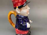 a figurine of a man with a red hat and a cane