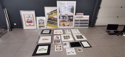 de nombreux tableaux encadrés posés par terre dans une pièce