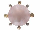 a close up of a pink stone surrounded by gold balls