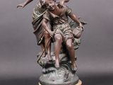 statue en bronze représentant une femme et un enfant sur un rocher