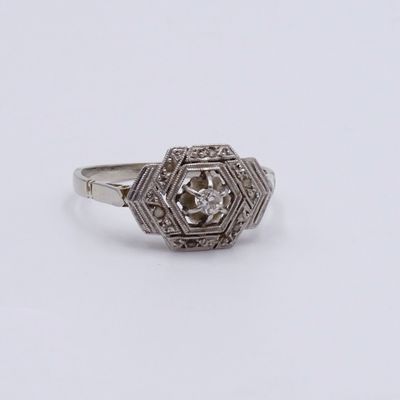 a close up of a diamond ring on a white surface