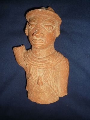 statue d'un homme coiffé d'un chapeau sur fond bleu