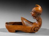 an image of a wooden sculpture of a woman in a boat