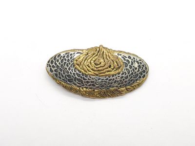 une broche en or et en argent sur un fond blanc