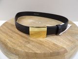 black leather belt with a gold buckle on a wooden plate