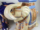 two ceramic elephants sitting next to each other on a table
